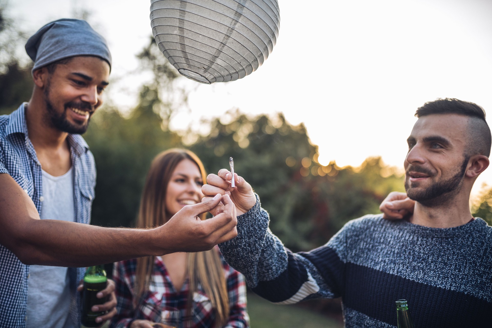 Youth passing a joint in a circle at a party